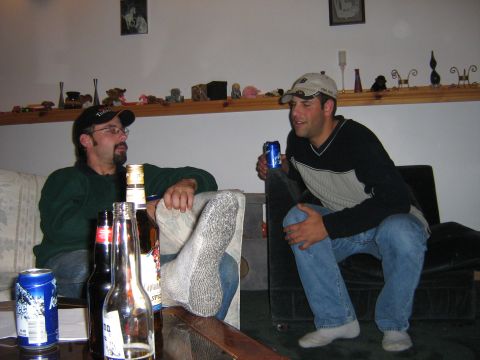 1995 Ford Bronco - Two men relax in a casual indoor setting, holding beverages and conversing.
