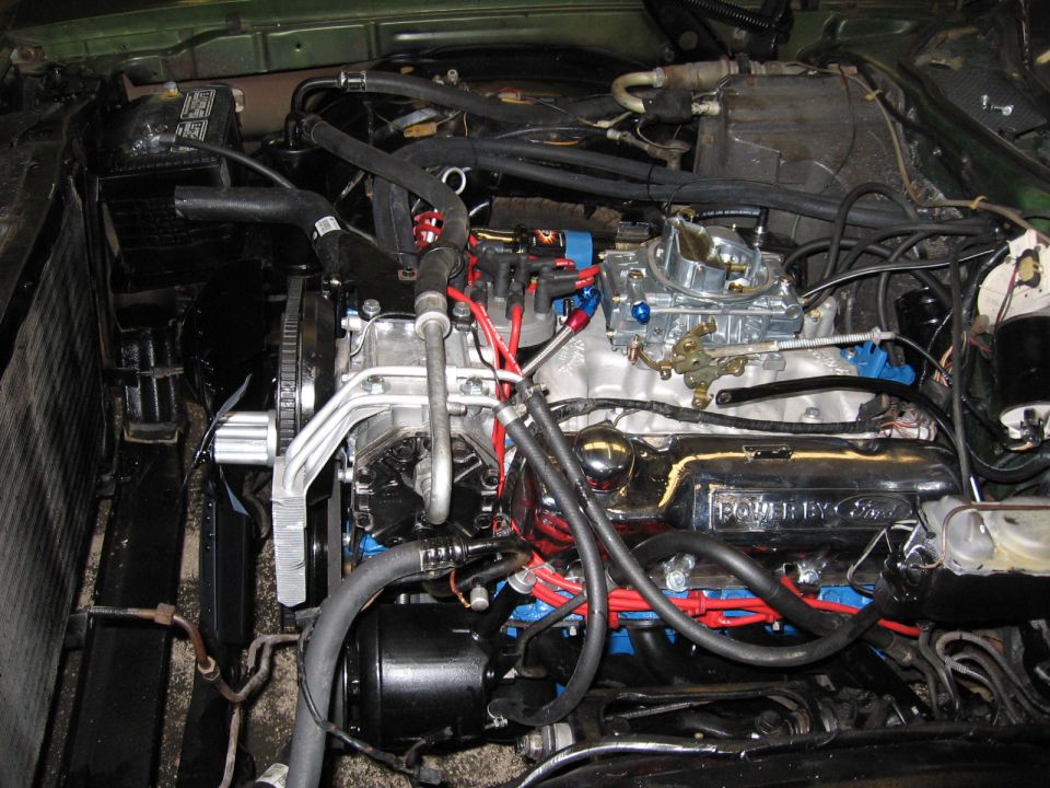 Engine bay with a V8 engine, carburetor, and "Powered by Ford" valve cover
