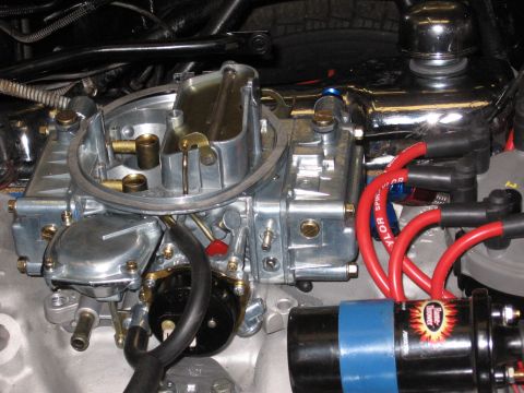 1973 Ford Ranchero - Close-up view of a vehicle's engine carburetor and ignition system components.