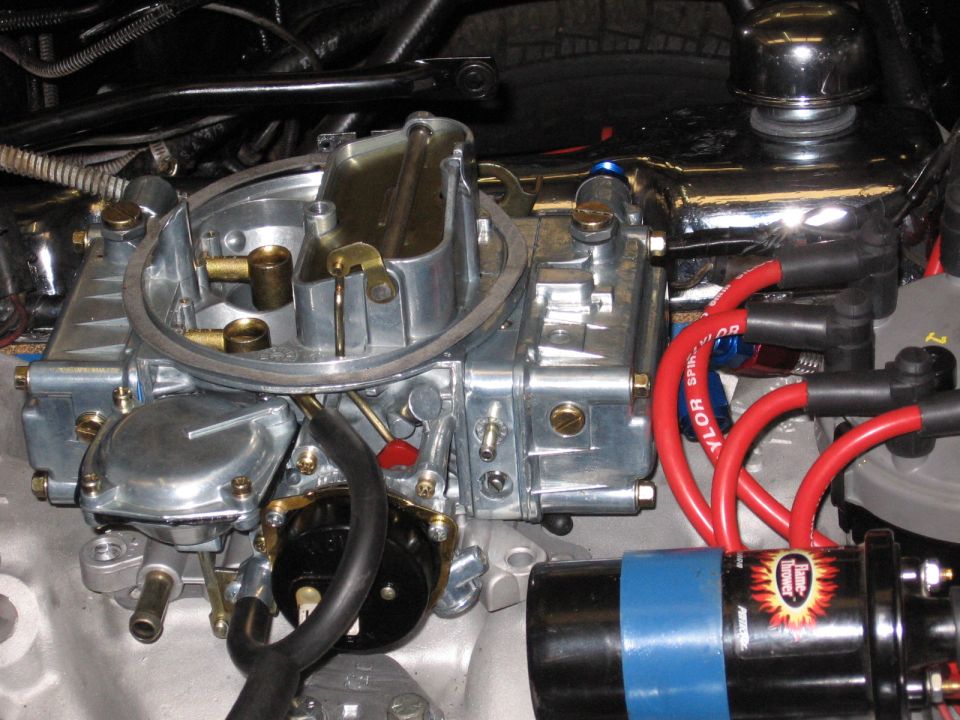Engine carburetor with red spark plug wires and a blue-banded ignition coil