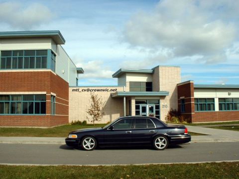 2000 Ford Crown Victoria - Side view of a 2000 Ford Crown Victoria parked outside a modern building.