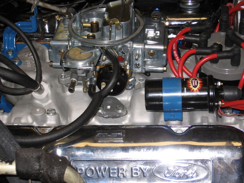 Engine bay with carburetor, ignition coil, and "POWER BY Ford" valve cover