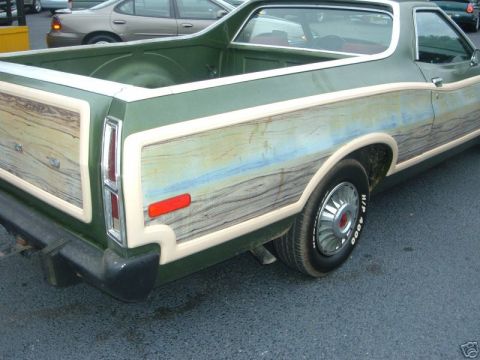 1973 Ford Ranchero - Rear view of a green pickup truck with distinctive wood-grain paneling on the side.