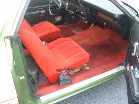 1973 Ford Ranchero - The interior of a 1973 Ford Ranchero features red velour seats and matching red carpet.