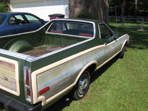 1973 Ford Ranchero - A green Ford Ranchero with distinctive wood grain side paneling sits on a grassy lawn next to another vehicle.