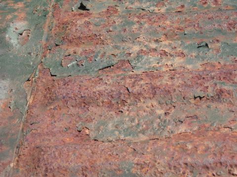1973 Ford Ranchero - Close-up of heavily rusted metal surface with flaking paint.