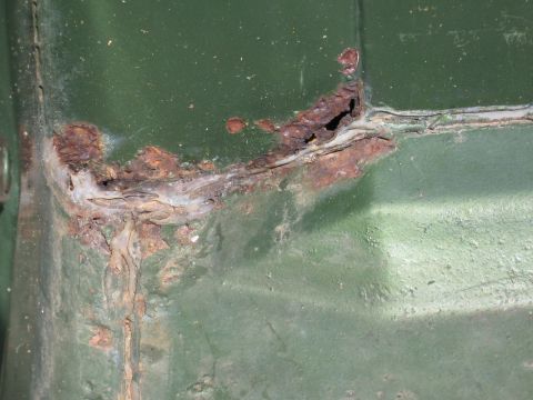 1973 Ford Ranchero - Significant rust and corrosion are visible on a green painted metal surface, indicating structural compromise.