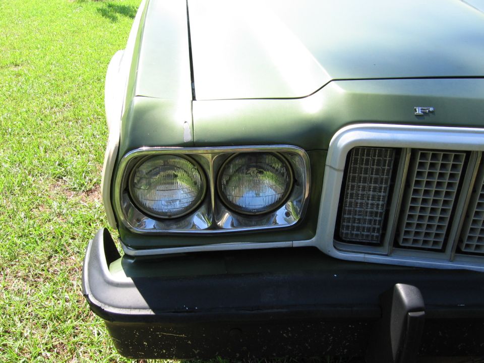 Front of a green 1972 Ford Ranchero showing headlights and grille