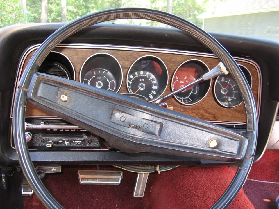1973 Ford Ranchero interior with woodgrain dash, four gauges, and black steering wheel