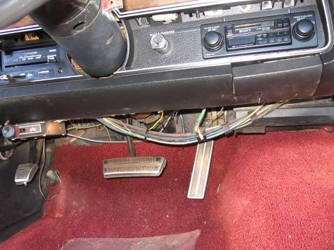1973 Ford Ranchero - Interior view of a car's dashboard, steering column, and pedals with exposed wiring.