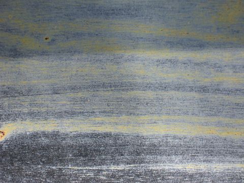 1973 Ford Ranchero - Weathered paint texture shows horizontal lines of blue, gray, and yellow with visible rust.