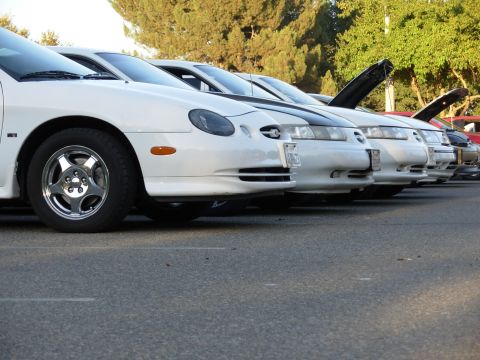 1995 Ford Taurus - Several 1995 Ford Taurus models are lined up with their hoods open.
