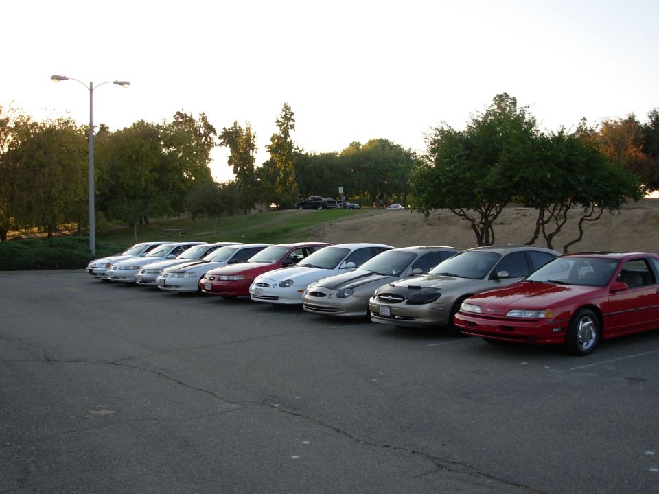 Red 1995 Ford Taurus coupe parked in a line of sedans