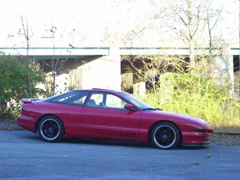 1997 Ford Probe - Red 1997 Ford Probe GTS coupe parked on asphalt with trees and an overpass in the background.