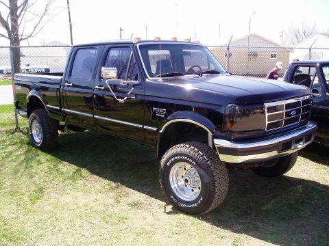 1986 Ford Bronco - This black Ford F-250 pickup truck has a four-door cab and is lifted with chrome wheels.