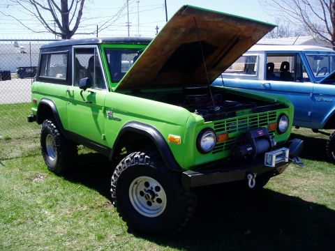 1986 Ford Bronco - Green Ford Bronco from the 1970s, with a second Bronco visible behind it.