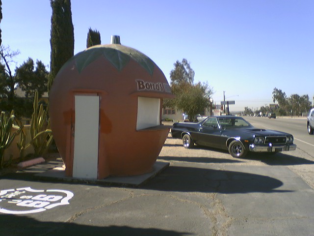1973 Ford Ranchero parked next to a tomato-shaped roadside stand