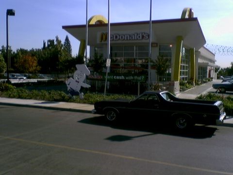 1973 Ford Ranchero - A black Ford Ranchero is parked in front of a McDonald's restaurant with a large cutout of the Hamburglar.