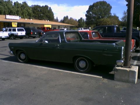 1973 Ford Ranchero - A dark green 1973 Ford Ranchero is seen from the side in a parking lot with other vehicles present.