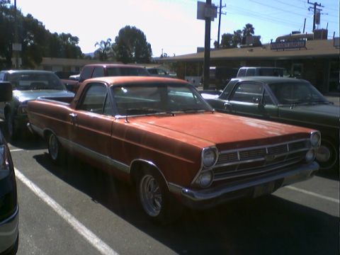 1973 Ford Ranchero - Orange Ford Ranchero parked in a lot with other vehicles.