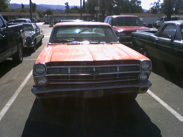 Front view of a red 1966 Ford Fairlane parked in a lot