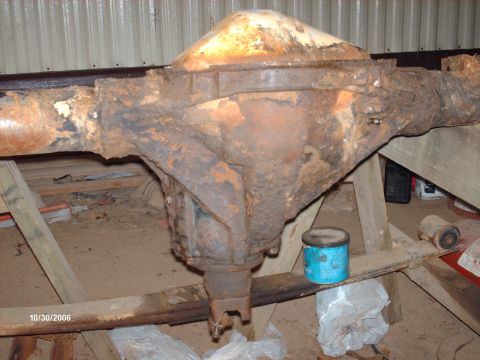 1990 Ford F-150 - Rear axle assembly, likely from a truck, sits on wooden supports in a workshop.