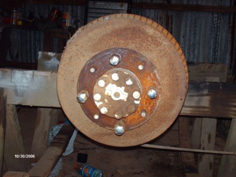1990 Ford F-150 - A close-up view of a heavily rusted brake rotor and hub assembly, likely a vehicle part.