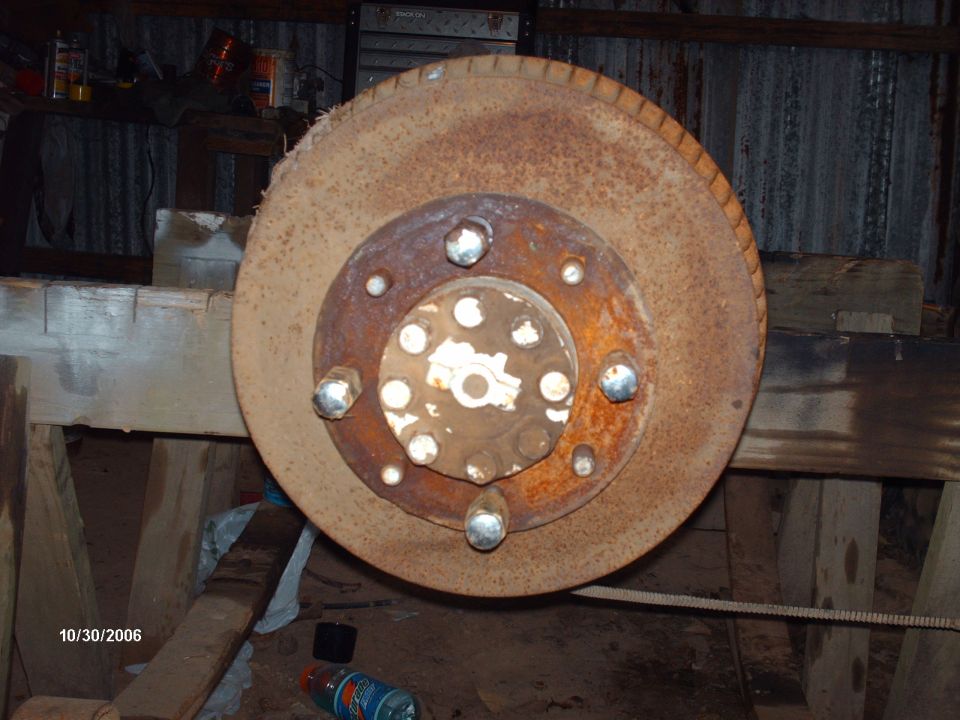 Rusty brake rotor with lug nuts and hub assembly, possibly from a truck
