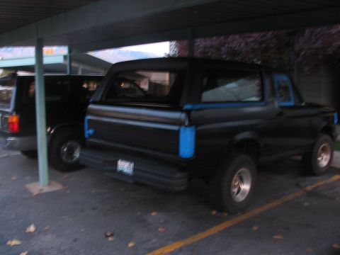 1991 Ford Bronco - Rear view of a black 1991 Ford Bronco parked under a carport.