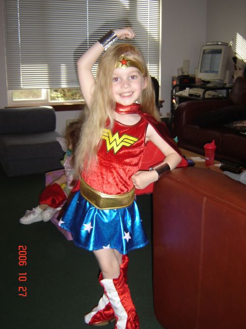 1993 Ford Bronco - A young girl dressed as Wonder Woman strikes a pose in a room with blinds and furniture.