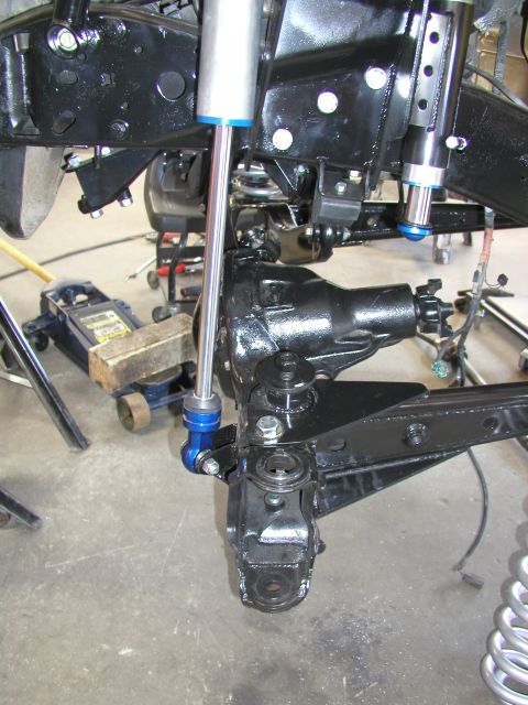1984 Ford Bronco - Close-up of custom front suspension components, including dual shock absorbers and steering linkage.