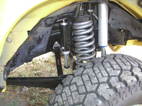 1984 Ford Bronco - This image shows the heavy-duty suspension system of an off-road vehicle, including shocks and a large tire.