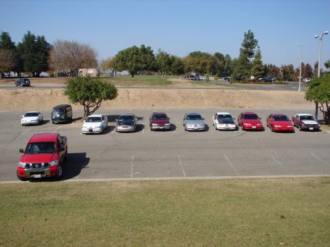 1992 Ford Taurus - A variety of cars are parked in an outdoor lot on a sunny day.