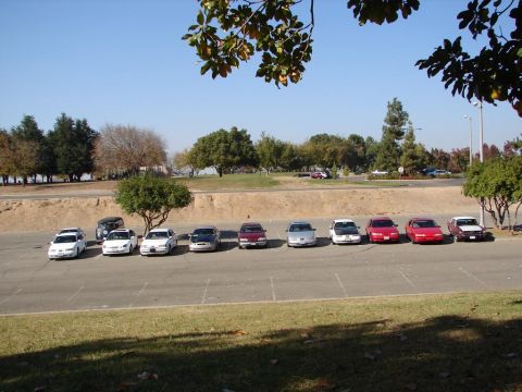 1992 Ford Taurus - A line of sedans, including a 1992 Ford Taurus, are parked in an outdoor lot under a clear blue sky.