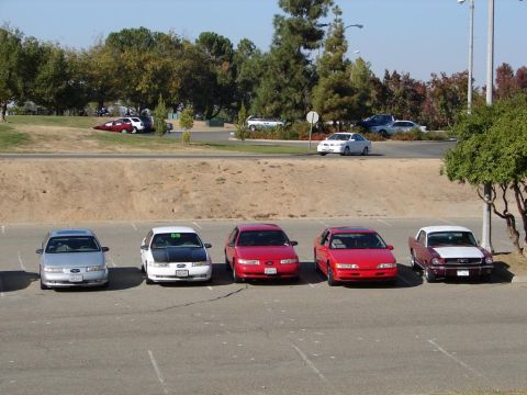 1992 Ford Taurus - A row of cars, including a silver 1992 Ford Taurus, are parked in an outdoor lot.