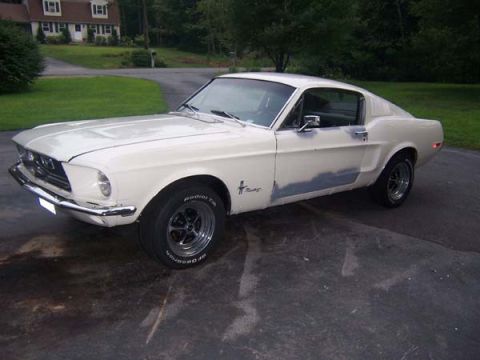 1968 Ford Mustang - White 1968 Ford Mustang coupe with primer patches on the driver's side body panels.