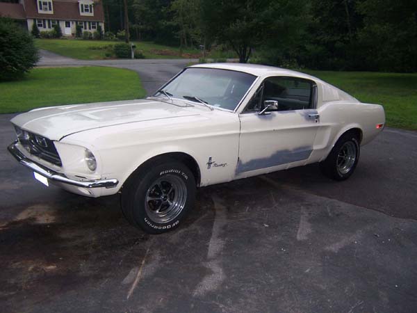 1968 Ford Mustang coupe, white with primer spots on driver's side door and fender