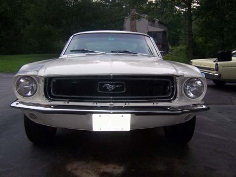 1968 Ford Mustang - A white 1968 Ford Mustang is parked in front of a house, with another car visible in the background.