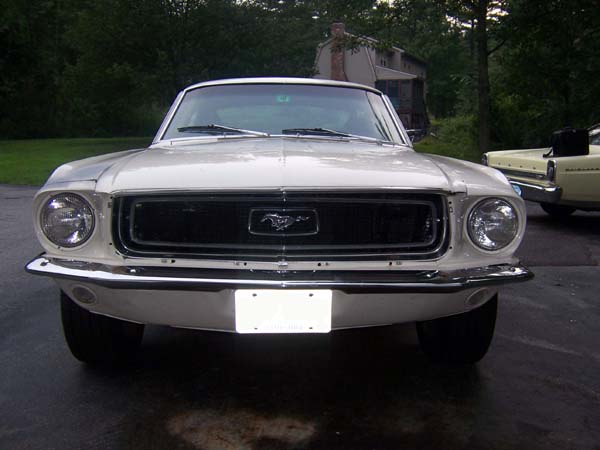 White 1968 Ford Mustang front view, chrome bumper, black grille with horse emblem, license plate area empty