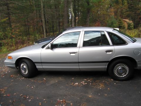 1991 Ford LTD Crown Victoria - This 1991 Ford Crown Victoria LTD is seen from the side, parked on an asphalt driveway with fallen leaves.