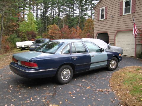 1991 Ford LTD Crown Victoria - A two-tone 1991 Ford Crown Victoria LTD sedan is parked in a driveway next to a garage.