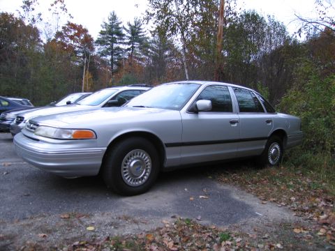 1991 Ford LTD Crown Victoria - A silver 1991 Ford Crown Victoria LTD sedan is parked in a lot with other vehicles visible.