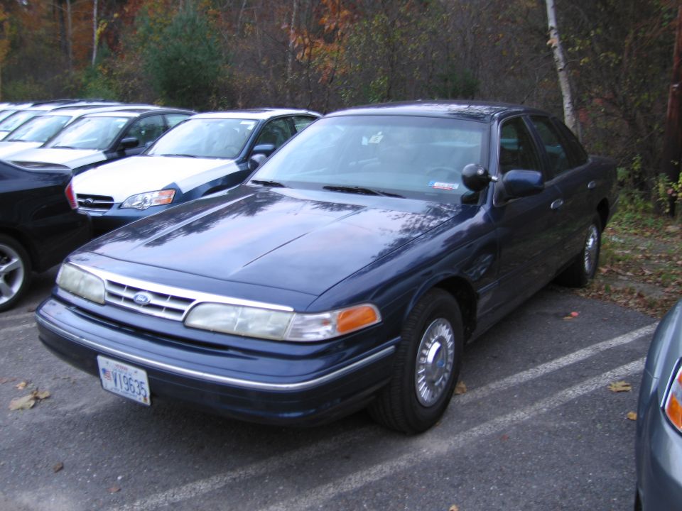 Dark blue Ford Crown Victoria Police Interceptor parked in a lot. License plate V19635