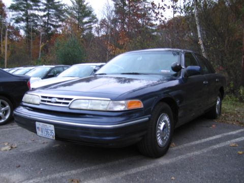 1991 Ford LTD Crown Victoria - A dark blue Ford Crown Victoria is parked in a lot with other vehicles visible.