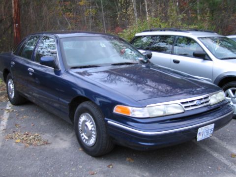 1991 Ford LTD Crown Victoria - A blue 1991 Ford Crown Victoria LTD sedan is parked next to a silver SUV.