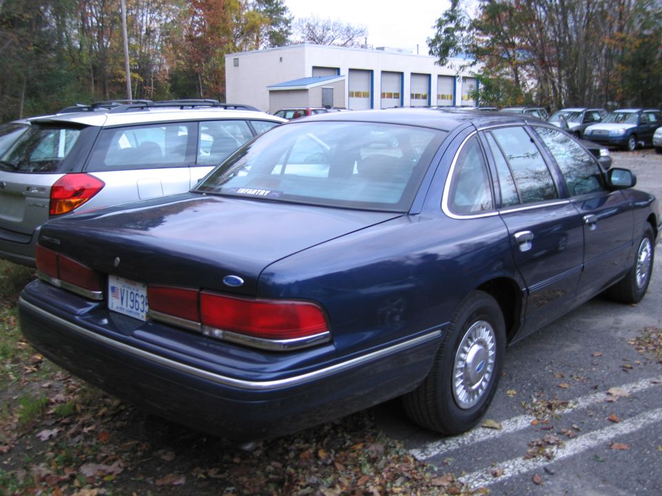 1991 Ford Crown Victoria LTD parked in a lot, rear view. License plate V1963