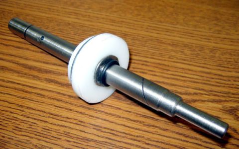1971 Ford Ranchero - A metal shaft with a white plastic disc and a black ring is shown against a wooden background.