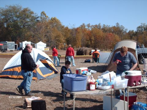 1995 Ford Probe - An outdoor event with tents set up, people milling about, and a spread of food on a table under a clear sky.