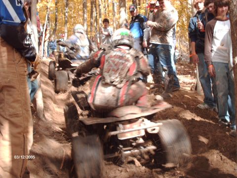 1995 Ford Probe - ATV riders navigate a challenging muddy course during a race event.