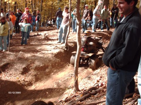 1995 Ford Probe - An all-terrain vehicle navigates a dirt path surrounded by trees and onlookers.